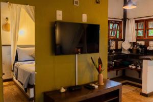 a living room with a bed and a flat screen tv at Villa Arumã Pousada in Alter do Chao