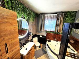 a bathroom with a tub and a toilet and a sink at NOCLEGI POD STODOŁĄ in Krakow +62 photos