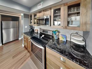 a kitchen with granite counter tops and wooden cabinets at Kontiki Bayfront Condo #710 in Rockport +23 photos