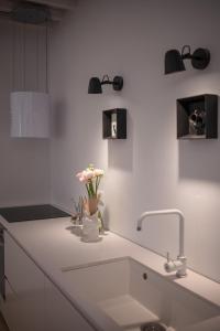 a kitchen counter with a sink and flowers in a vase at SaliScendi in Pietrasanta +13 photos