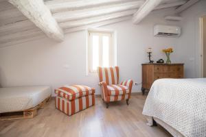 a bedroom with two beds and a chair at SaliScendi in Pietrasanta