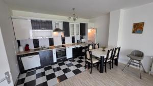 a kitchen with a checkered floor and a table and chairs at Struga Alpha House in Struga