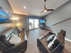 a living room with two leather couches and a flat screen tv at Kontiki Bayfront Condo #710 in Rockport