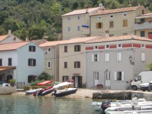a group of buildings and boats in the water at Valun Seaside Apartments in Valun