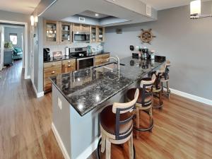 a kitchen with a large island with bar stools at Kontiki Bayfront Condo #710 in Rockport