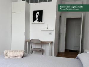 a bedroom with a bed and a chair and a table at Isola Chiara in Cagliari +6 photos