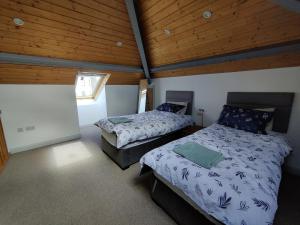 a bedroom with two beds and a wooden ceiling at 50-5 Coolyvenny in Killure