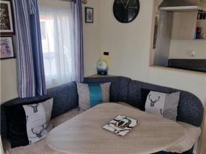 a living room with a couch and a table at Abi tebay oakfields towyn in Kinmel Bay
