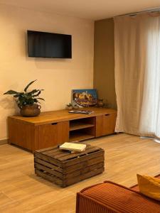 a living room with a tv on the wall at Hôtel Aghjola in Pioggiola