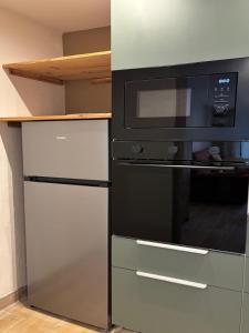 a microwave and a refrigerator in a kitchen at Hôtel Aghjola in Pioggiola