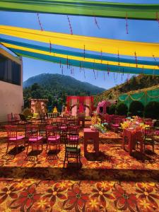 a group of tables and chairs on a patio at Rajvin Heavens Resort in Bhīm Tāl +19 photos