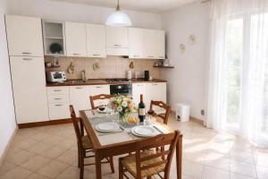 a kitchen with a table and chairs and a kitchen with white cabinets at HOUSE IN PARADISE - Realmonte with Free parking in Realmonte