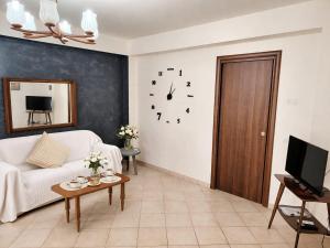 a living room with a couch and a clock on the wall at HOUSE IN PARADISE - Realmonte with Free parking in Realmonte