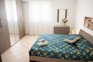 a bedroom with a bed with a blue comforter at HOUSE IN PARADISE - Realmonte with Free parking in Realmonte
