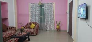 a living room with a couch and a tv at Peace Abode Vista in Dibrugarh