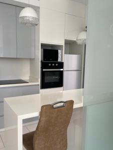 a kitchen with white cabinets and a table with a microwave at Casa Laguna Torrevieja in Torrevieja