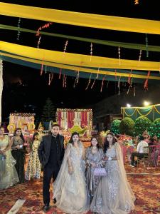 a bride and groom walking down the aisle with their wedding party at Rajvin Heavens Resort in Bhīm Tāl