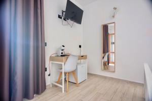a room with a desk with a computer and a chair at Zenia Rooms in San Teodoro