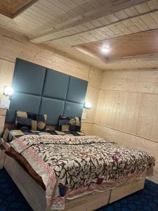 a bedroom with a bed in a room with wooden walls at Kashmir cottage in Pahalgām