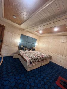 a bedroom with a bed in a wooden room at Kashmir cottage in Pahalgām