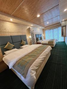 a large bedroom with two beds and a window at Kashmir cottage in Pahalgām