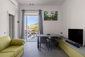 a living room with a couch and a table and a television at Sant'Erasmo luxury home in Palermo