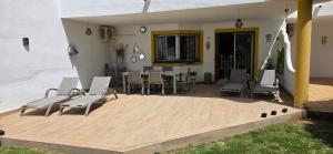 a patio with chairs and a table and a dining room at 7 Ocean Point in Sitio de Calahonda
