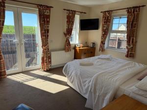 a bedroom with a bed and a large window at The Moorings in Edmondsley
