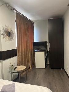 a room with a bed and a television and a table at A G Studio's Palas-Iasi 2 in Iaşi
