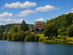 a house on a hill next to a lake at Hebels Auszeit in Heimbach