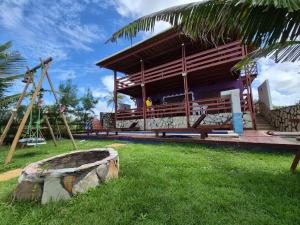 a building with a large rock in the grass at Ocean Drisana Guesthouse in Barra de Camaratuba