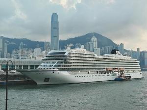 a cruise ship docked in the water with a city at Reliance Block C 12f in Hong Kong