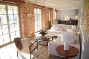 a living room with white furniture and a brick wall at Villa Casalís in Cubas