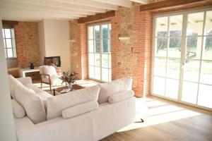 a living room with a white couch and a brick wall at Villa Casalís in Cubas