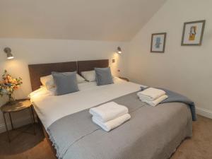 a bedroom with a large bed with white towels on it at Harvest Cottage 2 in Berwick-Upon-Tweed