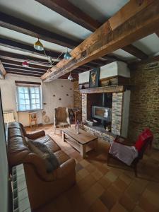 a living room with a couch and a fireplace at La Belangerie in Saint-Loup