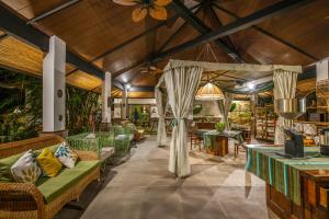 a restaurant with couches and tables in a room at Nawa Wellness in Calatagan