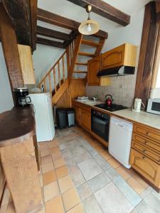 a kitchen with white appliances and wooden cabinets at La Belangerie in Saint-Loup