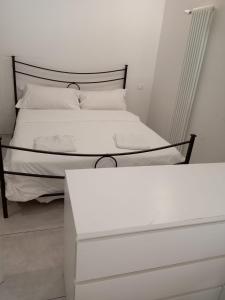 a bedroom with a white bed with a black headboard at Arcadia Hosting Aeroporto in Bologna