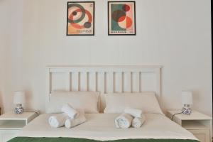 a white bed with four pillows on top of it at Casa Vacanza Nì Rosa in Cefalù