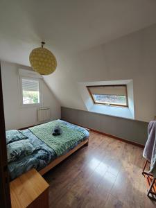 a bedroom with a bed and two windows in it at La Belangerie in Saint-Loup