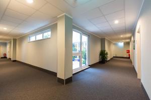 an empty hallway in an office building with a window at Hotel DH VEC in Vechta