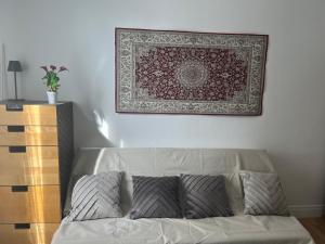 a couch in a living room with a rug on the wall at Petit cocon à 10 min de Paris in Cachan