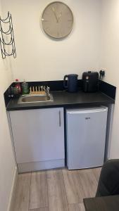 a kitchen with a sink and a clock on the wall at Brigstock 9 in Thornton Heath