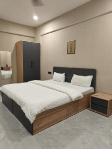 a bedroom with a large bed with white sheets at LivShared in Patna