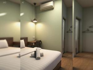 two pictures of a bedroom with two beds and a room with a desk at Hotel O Green Home Hotel in Sepang