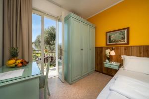 a bedroom with a bed and a table with a bowl of fruit at Hotel Silvana Garnì in Limone sul Garda