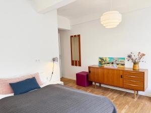 a bedroom with a bed and a wooden dresser at Seven Rooms Hamburg in Hamburg