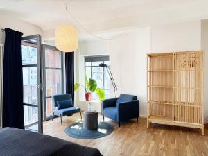 a bedroom with a bed and two chairs and a lamp at Seven Rooms Hamburg in Hamburg