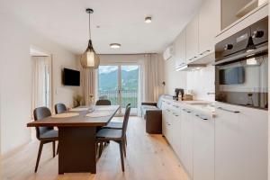 a kitchen and dining room with a table and chairs at Gisshübelhof Apartments in Lana